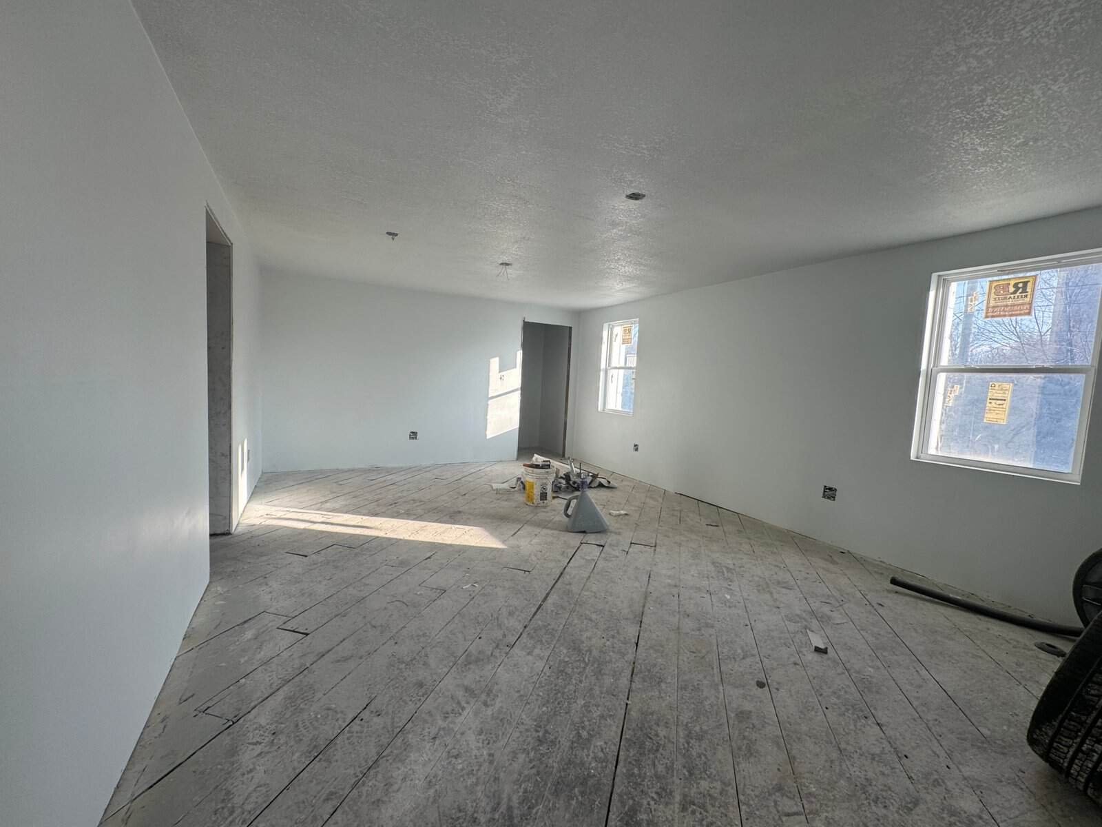 Interior room under construction with unfinished flooring and white walls, showcasing the use of durable Cordura RE fabric for renovation projects.