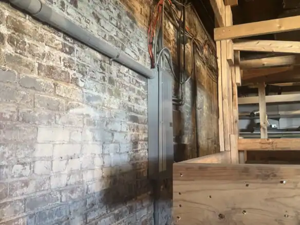 Industrial setting showcasing Cordura RE fabric used in construction with electrical wiring and wooden framework in a warehouse or workshop environment.