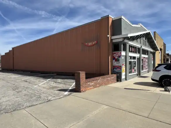 Exterior view of a building with Cordura RE branding, showcasing the durable fabric used in outdoor and industrial applications, with parking lot and clear sky.
