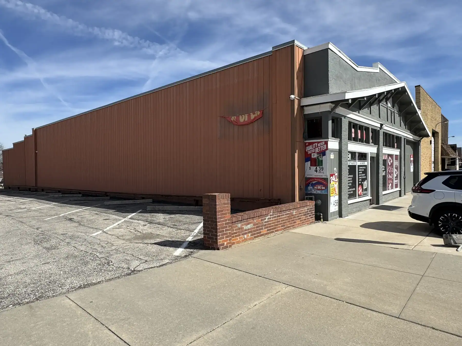 Exterior view of a building with Cordura RE branding, showcasing the durable fabric used in outdoor and industrial applications, with parking lot and clear sky.