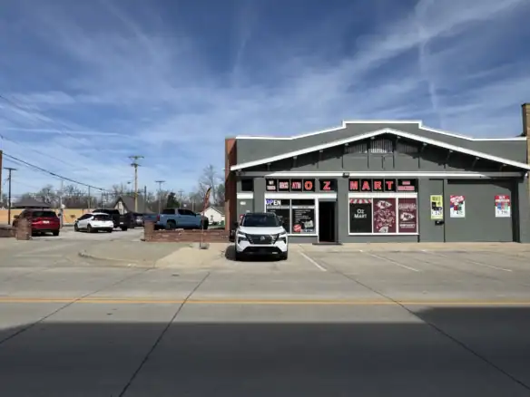 View of Cordura RE store exterior showcasing its storefront with signage and parking lot, under a clear blue sky.